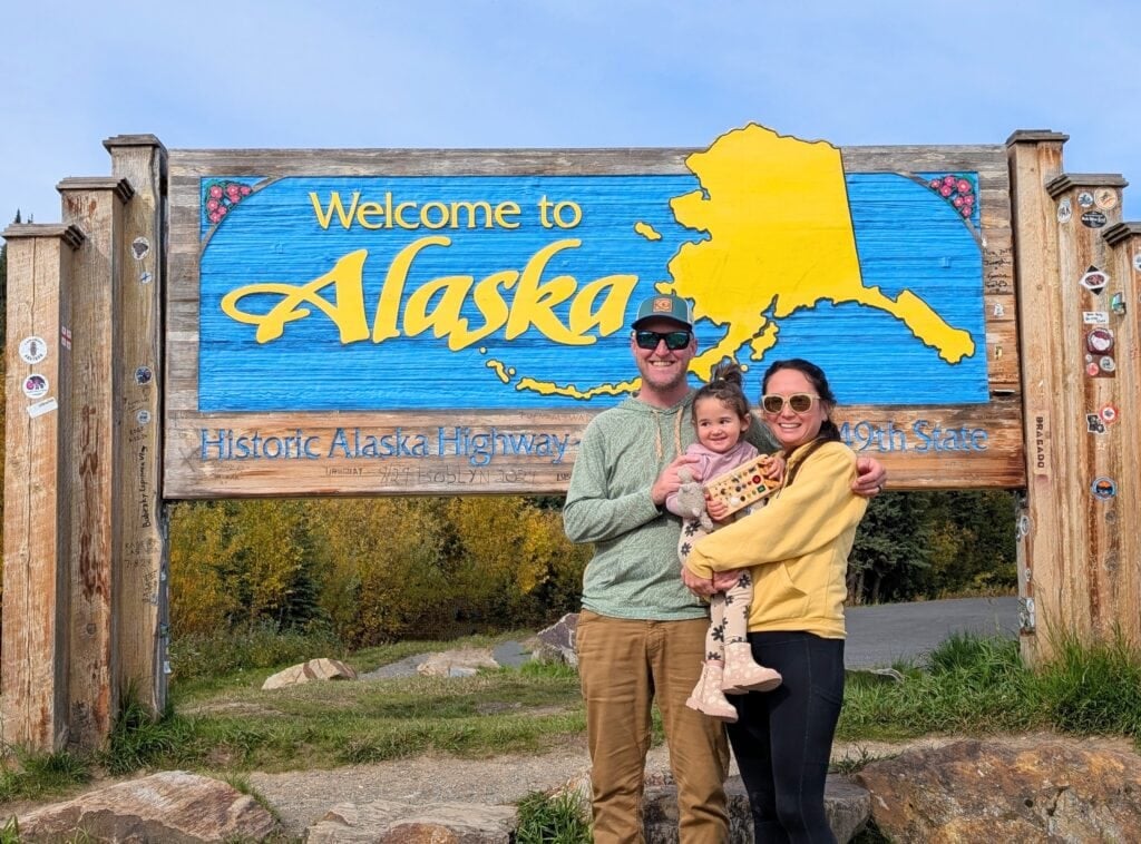 Picture of me and my family in front of the Alaska state sign. How I’m Working Just a Few Hours a Week This Summer (And Still Earning Full-Time Income)
